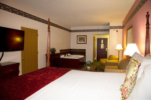 a hotel room with a large bed and a bathroom at Hotel Grand Victorian in Branson