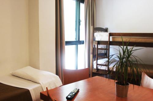 Habitación con cama y mesa con mando a distancia. en Apartamentos Montegorbea, en Sierra Nevada