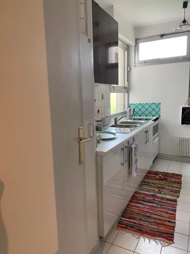 eine Küche mit weißen Schränken und einem Waschbecken in der Unterkunft Jolie chambre privée à Paris dans appart de 75m2 in Paris