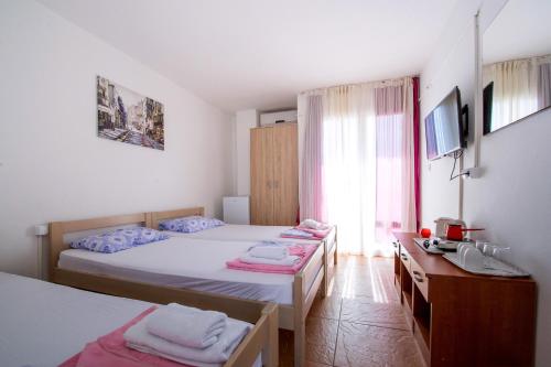 a hotel room with two beds and a window at Guest House Lotos in Bečići