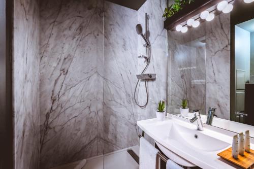 a bathroom with a sink, mirror, and bath tub at The ReMIX Hotel in Paris