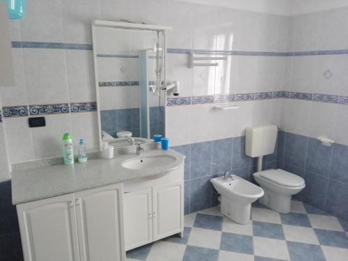 un bagno blu e bianco con lavandino e servizi igienici di La Sofiètta a Borgo San Dalmazzo