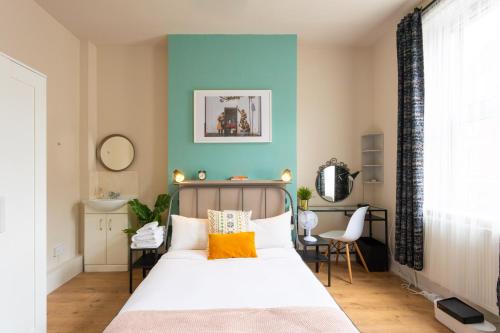 - une chambre avec un lit et un mur bleu dans l'établissement Tavistock Place Rooms by MoreThanStays, à Londres