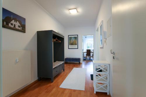 een woonkamer met een zwarte kast en een houten vloer bij Ferienwohnung Leipzig Land in Naunhof