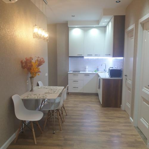 a kitchen with a table and chairs and a sink at Nova city center apartments in Tbilisi City