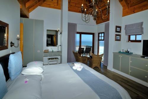 a bedroom with a large bed with a view of the ocean at Dolphin Dunes Guesthouse in Wilderness