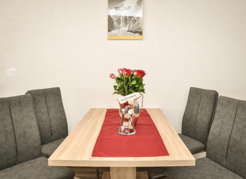 a table with two chairs and a vase with flowers at apart-wolf-arlberg in Warth am Arlberg