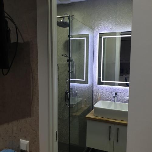 a bathroom with a glass shower and a sink at Nova city center apartments in Tbilisi City