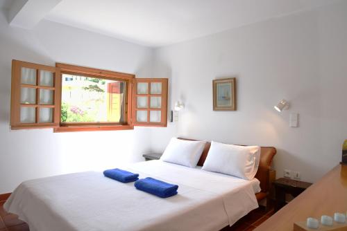 アナヴィソスにあるVilla Falmyのベッドルーム1室(白いベッド1台、青いタオル2枚付)