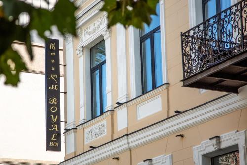 a sign on the side of a building with a balcony at Royal Inn in Tbilisi City