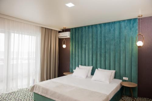 a bedroom with a large bed with a green wall at AURUM FAMILY RESORT & SPA in Blagoveshchenskaya