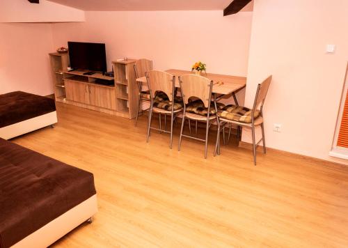 New Star Residence في مدينة بورغاس: غرفة معيشة مع طاولة وكراسي وتلفزيون
