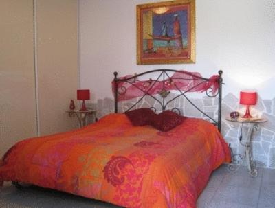 a bedroom with a red bed with two tables and two lamps at L'Isola Felice e Trulli Sotto Le Stelle in Castellana Grotte