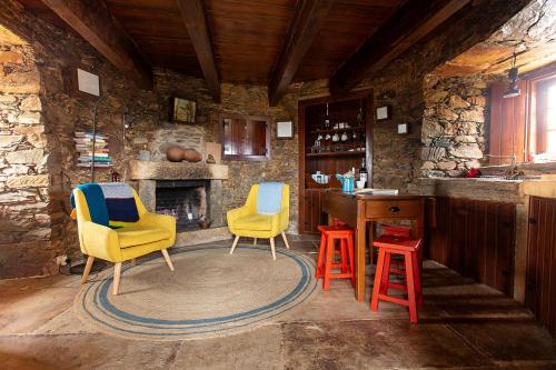 una habitación con 2 sillas y un bar con chimenea en Moinho da Fadagosa, en Mação