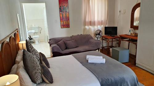 a bedroom with a large bed and a couch at Lake Motel in Hartbeespoort