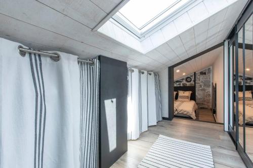 une chambre avec un lit et une lucarne dans l'établissement Annecy 200m du lac grande terrasse de vignes calme & unique, à Annecy