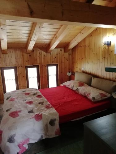 1 dormitorio con 1 cama en una cabaña de madera en Mansarda en Champorcher