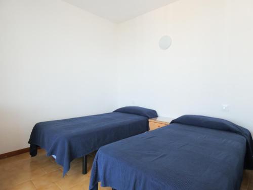 Dos camas en una habitación con sábanas azules. en Bora 6-D, en Roses