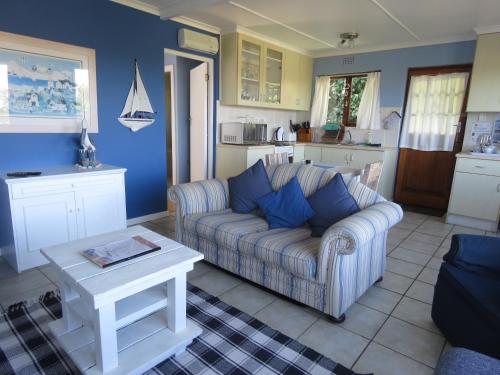a living room with a couch and a table at Footprints of Knysna in Knysna