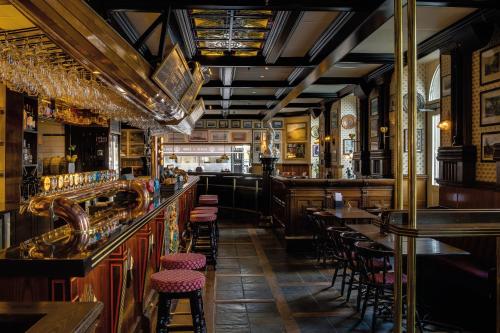 a bar with tables and stools in a pub at Elite Stora Hotellet in Jönköping