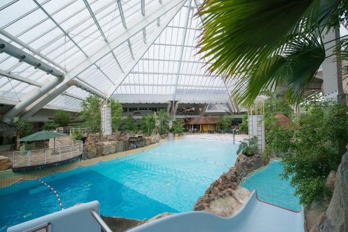 een groot zwembad in een gebouw met een plafond bij Sunparks Kempense Meren in Mol