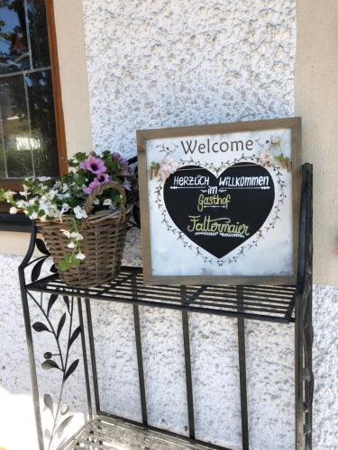 a sign on a table with flowers and a basket at Gasthaus-Hotel Faltermaier in Eicherloh