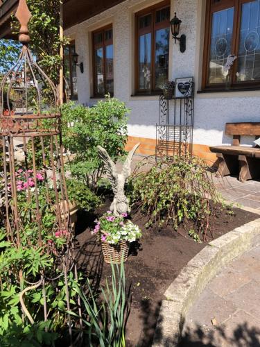 a garden with flowers and a statue of a rabbit at Gasthaus-Hotel Faltermaier in Eicherloh