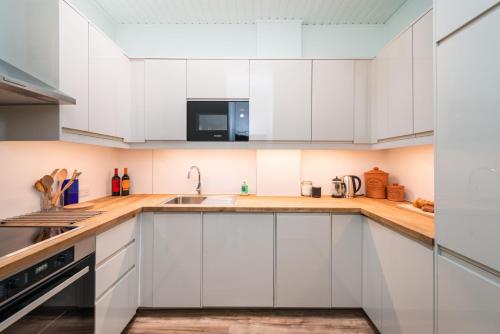 a kitchen with white cabinets and a sink at Kings Stables, Grassmarket in Edinburgh
