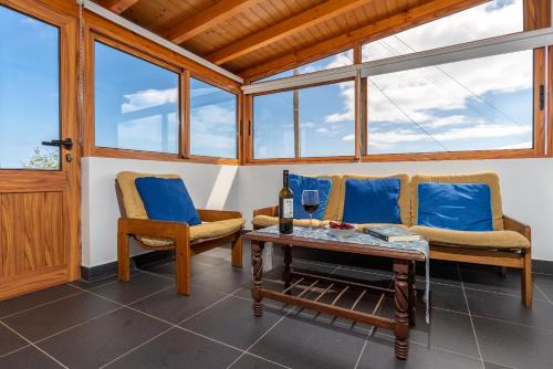 a living room with two chairs and a table at Casa Raivinha in Arco da Calheta