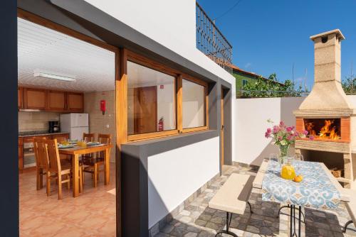 a kitchen and dining area of a house with a fireplace at Casa Raivinha in Arco da Calheta