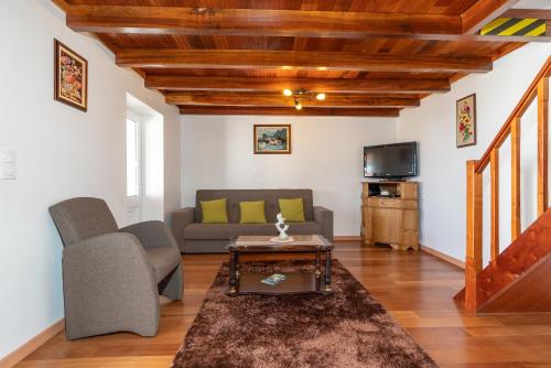 a living room with a couch and a tv at Casa Raivinha in Arco da Calheta