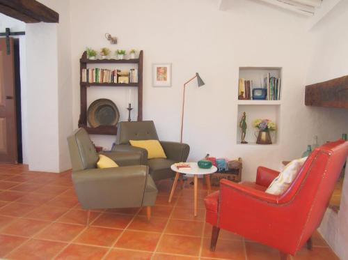 a living room with two chairs and a table at Monte dos Freixos Country House in São Lourenço de Mamporcão