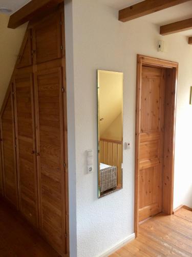 a bedroom with wooden doors and a mirror on the wall at Hus Nordhauk in Borkum