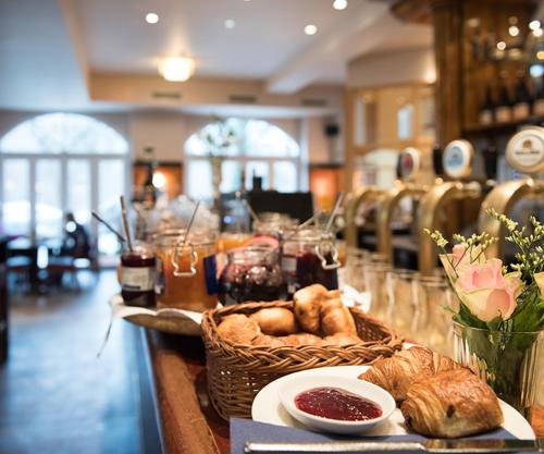 een tafel met brood en een mand met gebak bij Hotel Ritzi in München