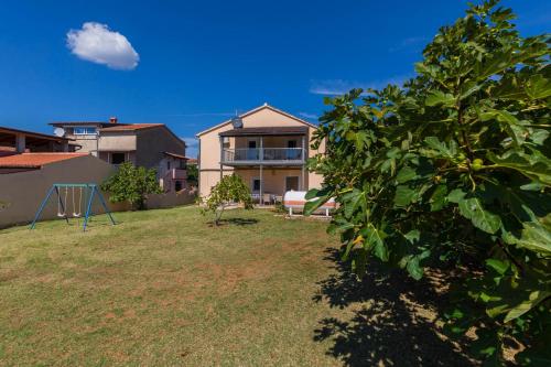 a view of a yard with a house at Apartments Ankica Blue in Peroj