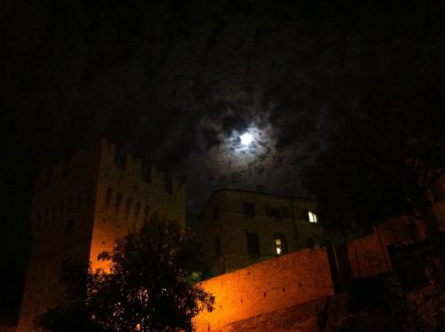 a full moon in the sky over buildings at night at B&B La Lanterna in Fermo