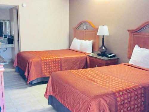 una camera d'albergo con due letti e una lampada di Masters Inn a Seffner