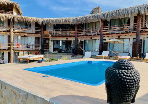 a resort with a swimming pool in front of a building at Buena Vista Lobitos in Lobitos