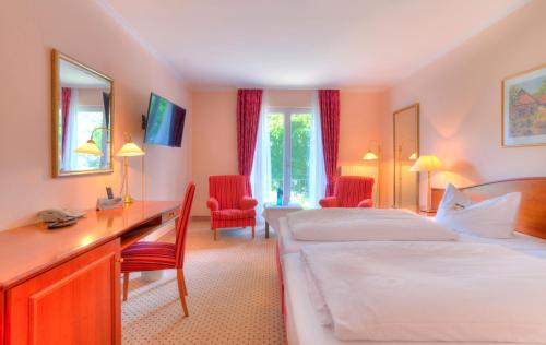 a hotel room with two beds and a desk at Hotel Döllnsee-Schorfheide in Templin