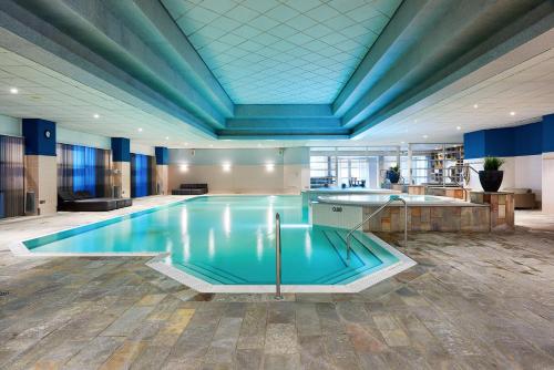 een groot zwembad in een gebouw met een blauw plafond bij HUP in Mierlo
