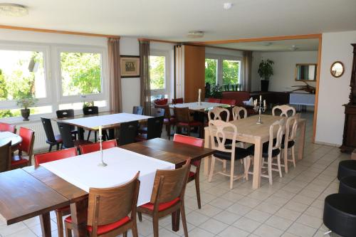 a dining room with tables and chairs and windows at Hotel-Krone-Lounge in Herdwangen-Schönach