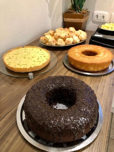 a table with three different types of cakes on it at Hotel Concatto in Farroupilha