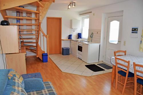 a kitchen and a living room with a table and chairs at Ferienwohnungen Familie Looks in Klein Zicker