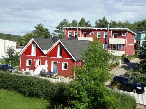 a red house with a black roof at PONTUS Ferienwohnung FeWo4 in Zislow