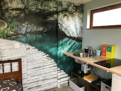 ein Bad mit einem Wandbild mit Wasserfall in der Unterkunft Cabane du hérisson in La Capelle-en-Thiérache