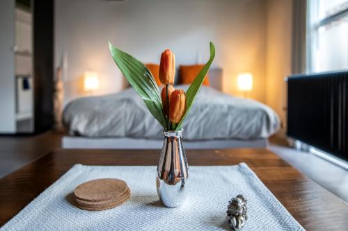a vase with orange tulips in it on a table at Stadslogement Bij de Sassenpoort in Zwolle