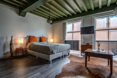 a bedroom with a bed and two windows at Stadslogement Bij de Sassenpoort in Zwolle
