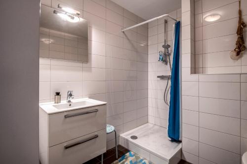 a white bathroom with a sink and a shower at Stadslogement Bij de Sassenpoort in Zwolle