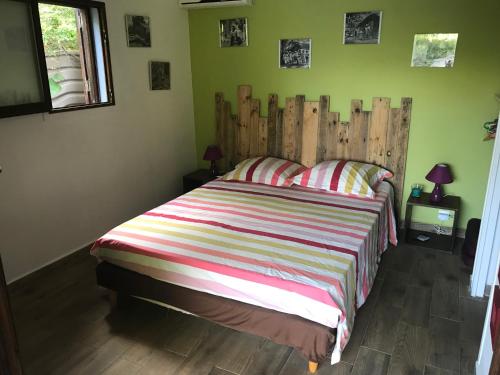 a bedroom with a large bed with a wooden headboard at un bungalow au paradis in Saint-Pierre