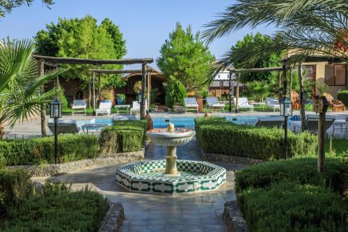 a fountain in the middle of a courtyard with a pool at Taloute Ecolodge in Skoura